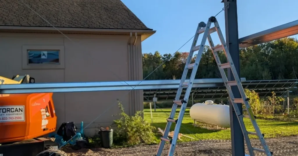 Steel building frame installation in Ontario showing ladder, beams, and lift equipment during erection by Tower Steel Buildings