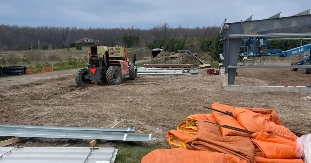 Ontario steel building construction site by Tower Steel Buildings showing materials and equipment during site preparation and zoning compliance checks