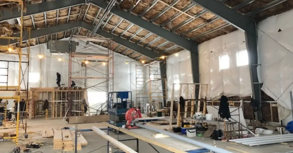 Ontario commercial steel building under construction showing insulation, scaffolding, and structural framing during foundation preparation