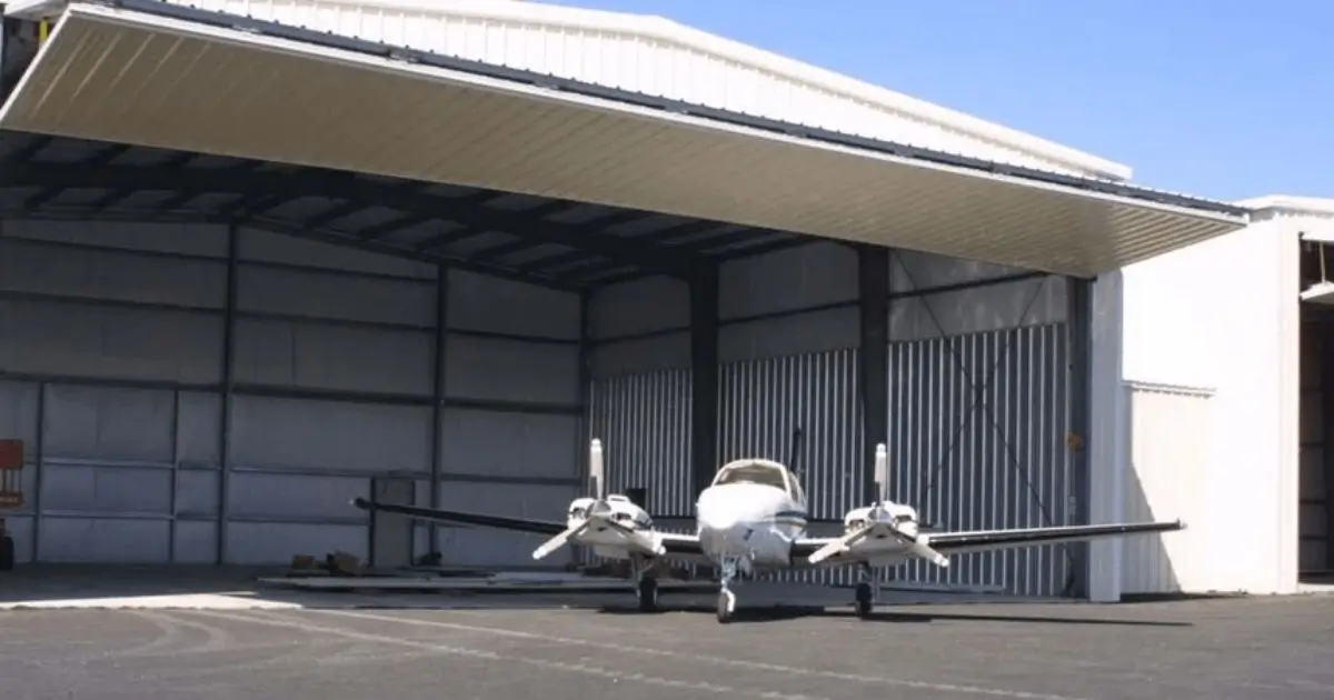 Steel aircraft hangar in Ontario with a twin-engine airplane parked at the wide open entrance