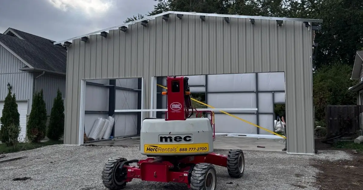 Partially constructed beige steel building in Ontario by Tower Steel Buildings showing durable panels and professional installation equipment