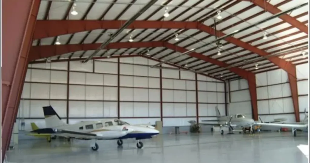 Interior view of a steel aircraft hangar in Ontario with red frame and parked airplanes