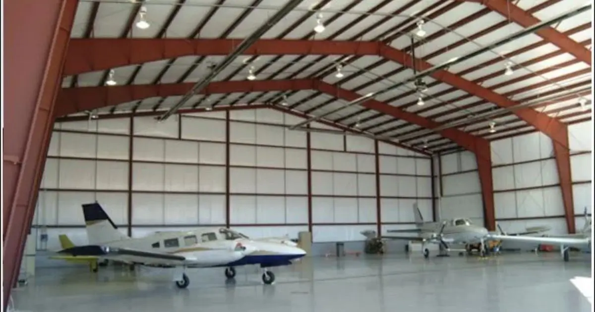 Interior view of a steel aircraft hangar in Ontario with red frame and parked airplanes