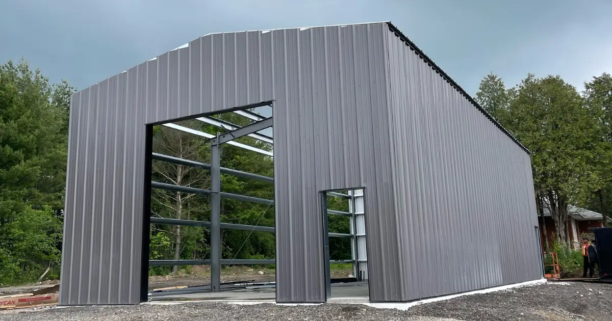 Steel building under construction in Canada showing steel frame and exterior cladding, illustrating how balanced engineering avoids over-engineering and under-engineering costs.
