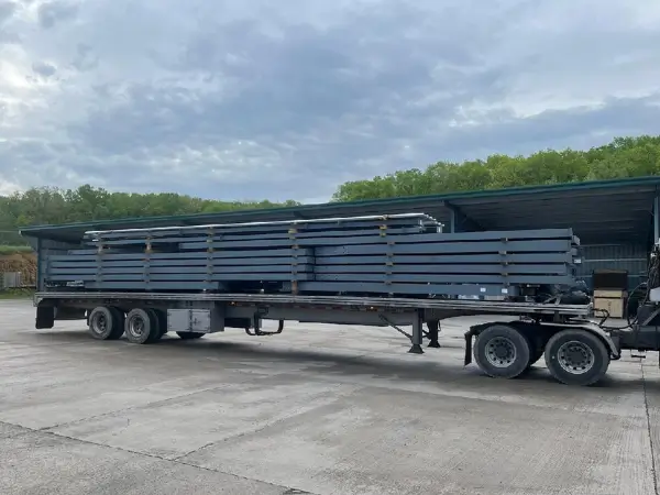 Steel building kits loaded on flatbed trailer for delivery across Ontario, manufactured in Canada and engineered for local building codes.