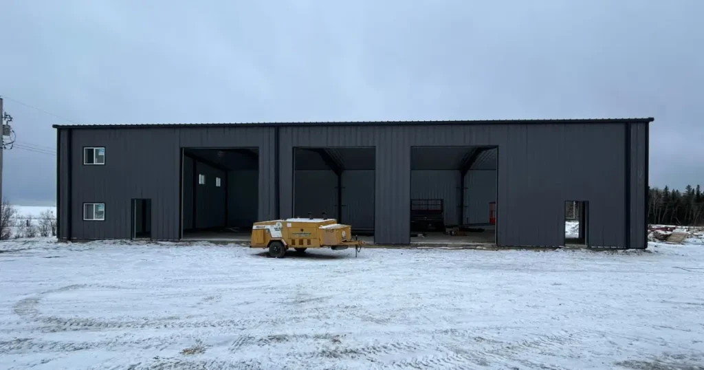 Steel warehouse designed with wide bay spacing, high clear height, and large door openings to support racking and forklift clearance