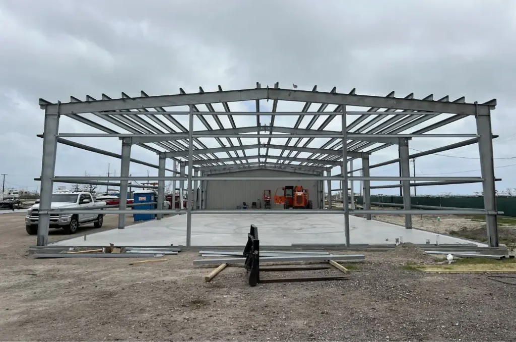 50x100 steel building frame under construction showing structural steel and foundation slab