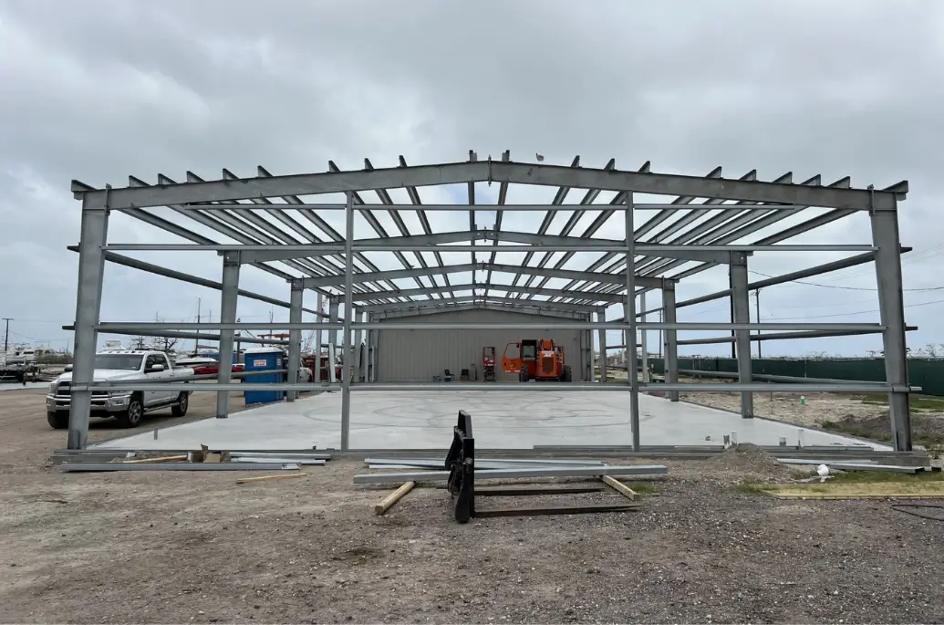 50x100 steel building frame under construction showing structural steel and foundation slab